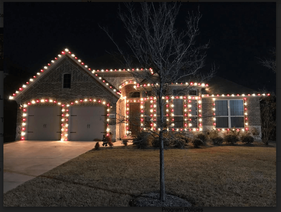 Installer mounting professional LED Christmas lights on a roofline