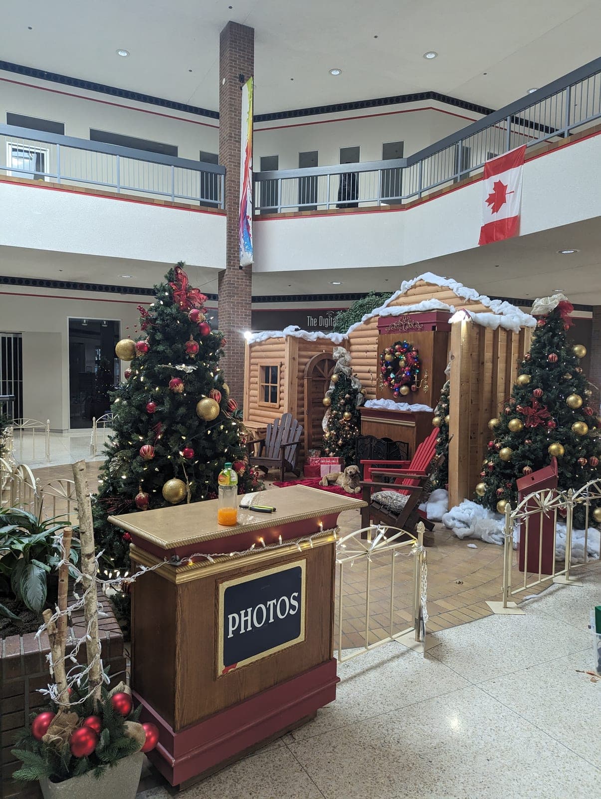 Shopping mall Christmas photo booth with a Santa's cabin backdrop and ornament-covered trees