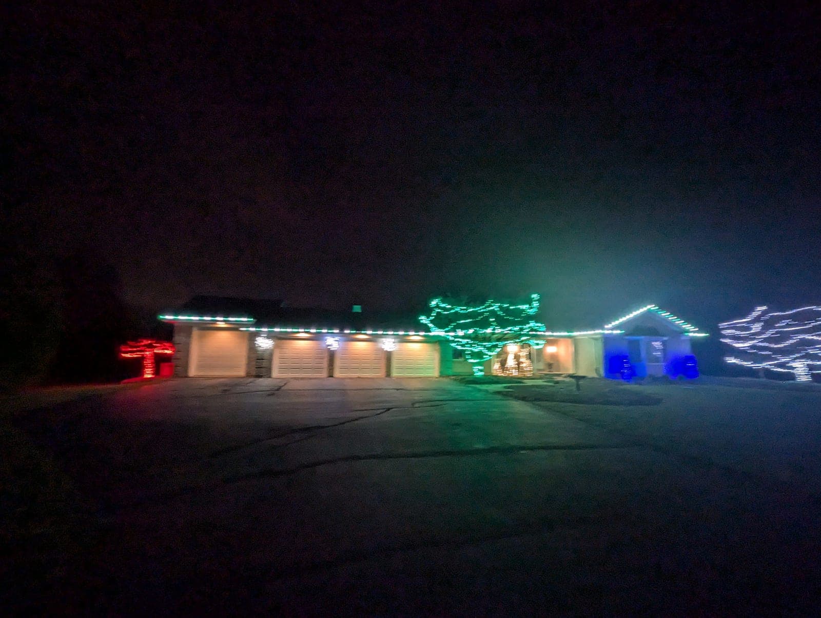 Ranch home with a full multicolour Christmas light display across the roofline and yard