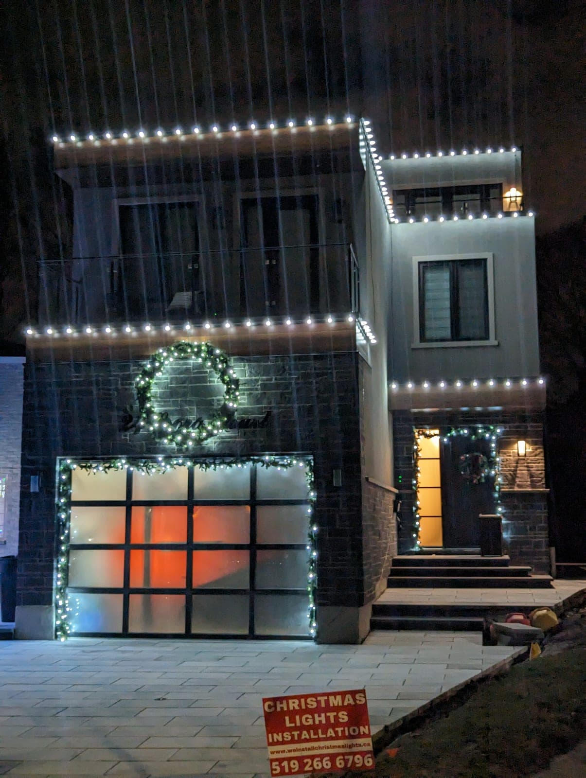 Crisp warm-white C9 roofline Christmas lights outlining a two-storey home exterior